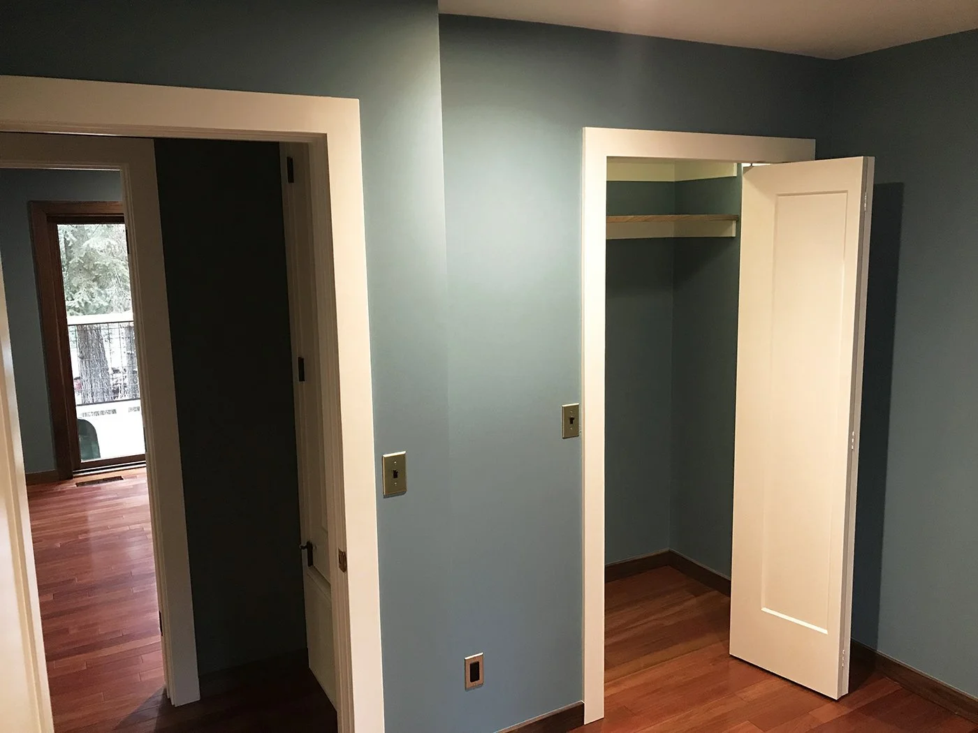freshly painted interior with blue walls wooden floor and partially open closet door by eagle bear construction