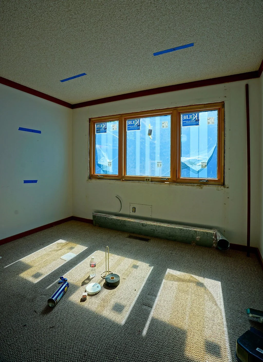 tools and tape on ceiling in room with new windows