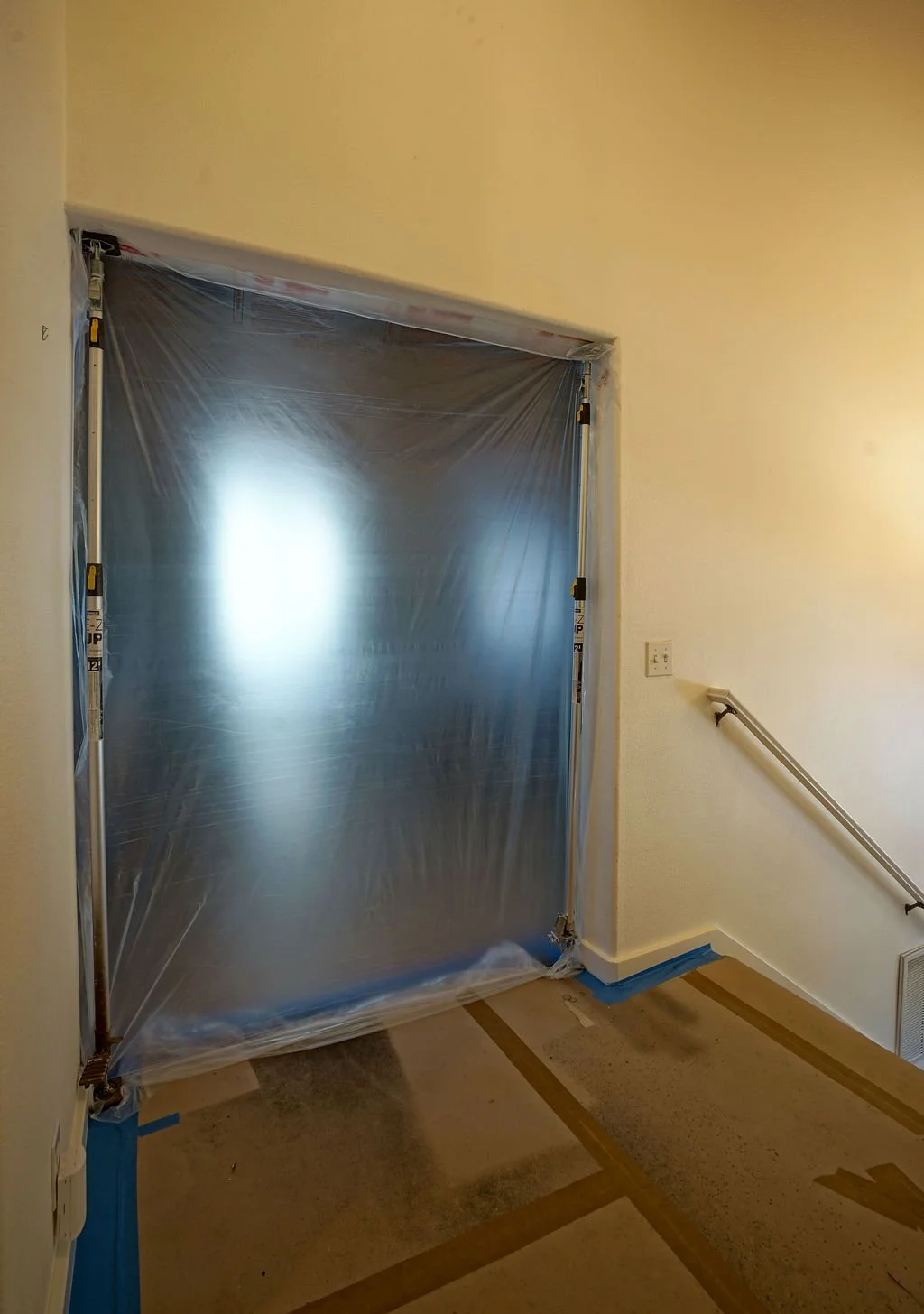 doorway with blue painters tape and white walls