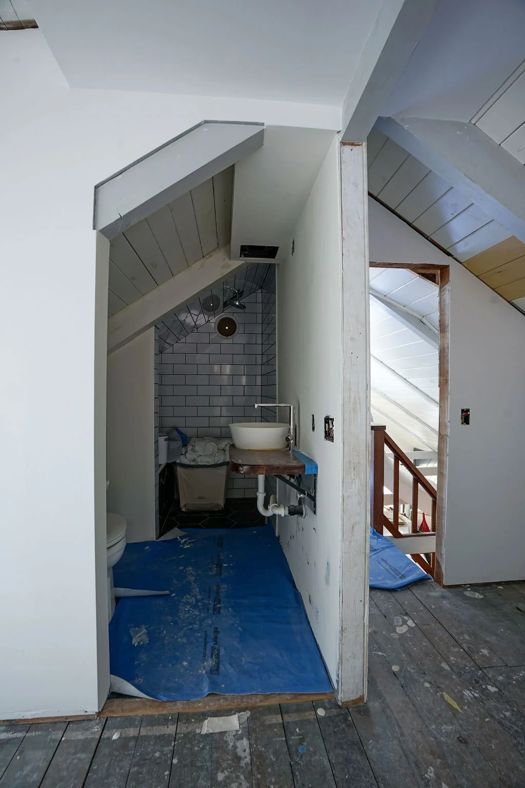 bathroom prepped for remodel with blue floor covering for protection