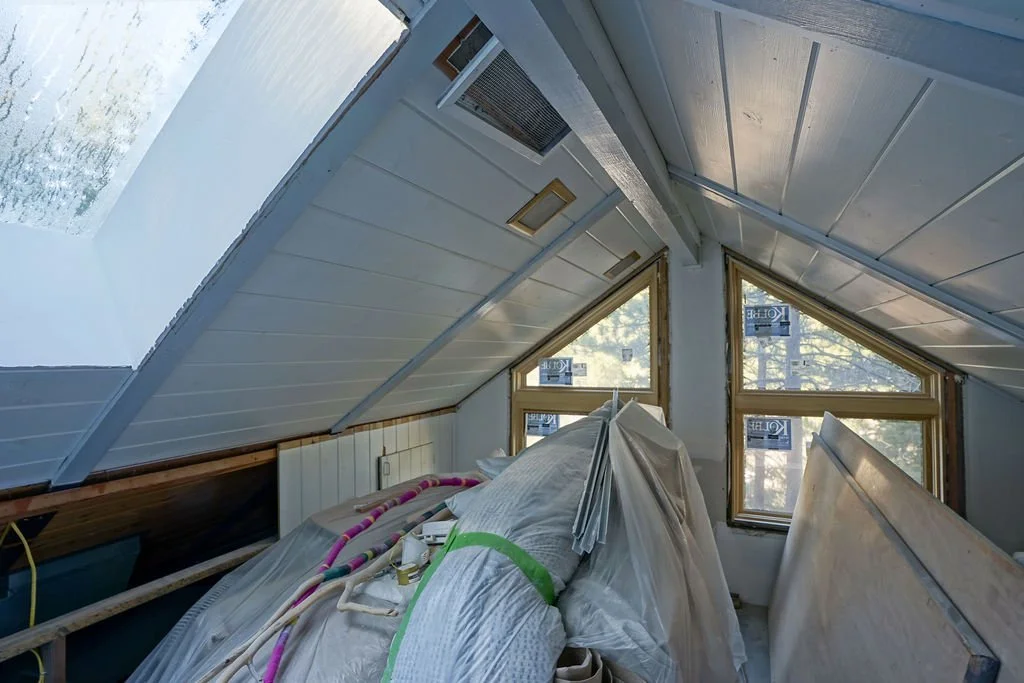 angled white ceilings and skylight in small upstairs room