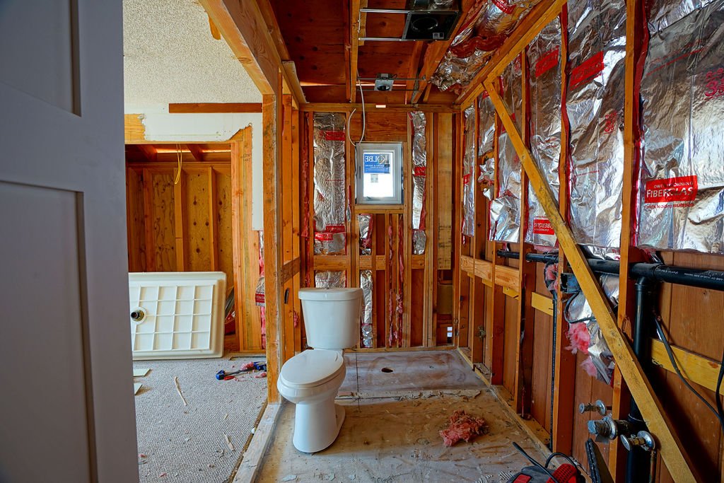 bathroom remodel with white toilet and framing and insulation 