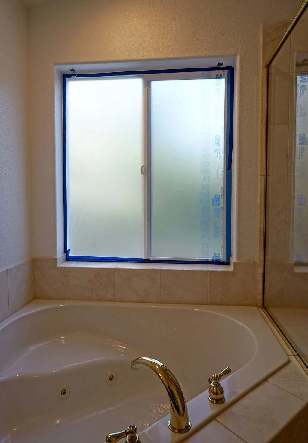 large bathtub below window with tape