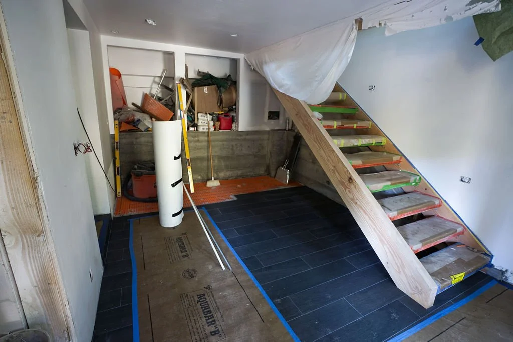 wooden stairs to basement with paper covering floor and stairs