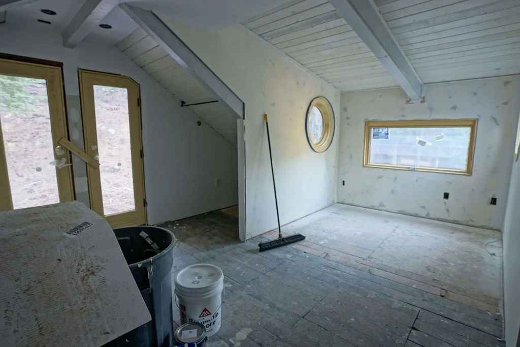 bedroom with windows and door stripped floor and walls