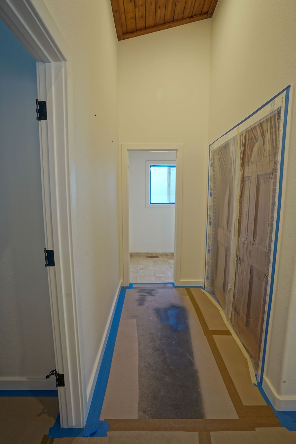 hallway with floor and doors taped for protection from paint