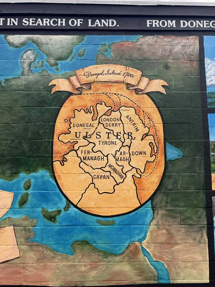 A historical map on a wall showing counties of Donegal, Ireland in the 1700s, with a banner at the top indicating Donegal, Ireland, 1700s.