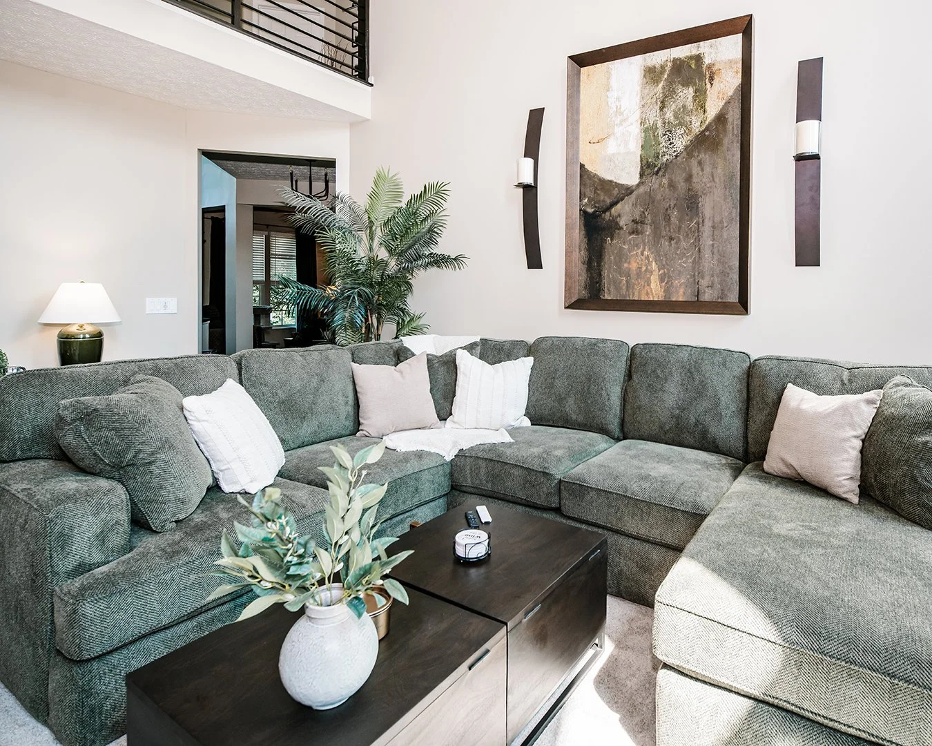Living Room Sectional with Abstract Art and Candles on Wall