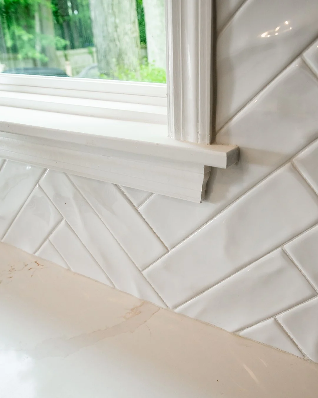 White Herringbone Tile Backsplash in Kitchen with Quartz Countertops