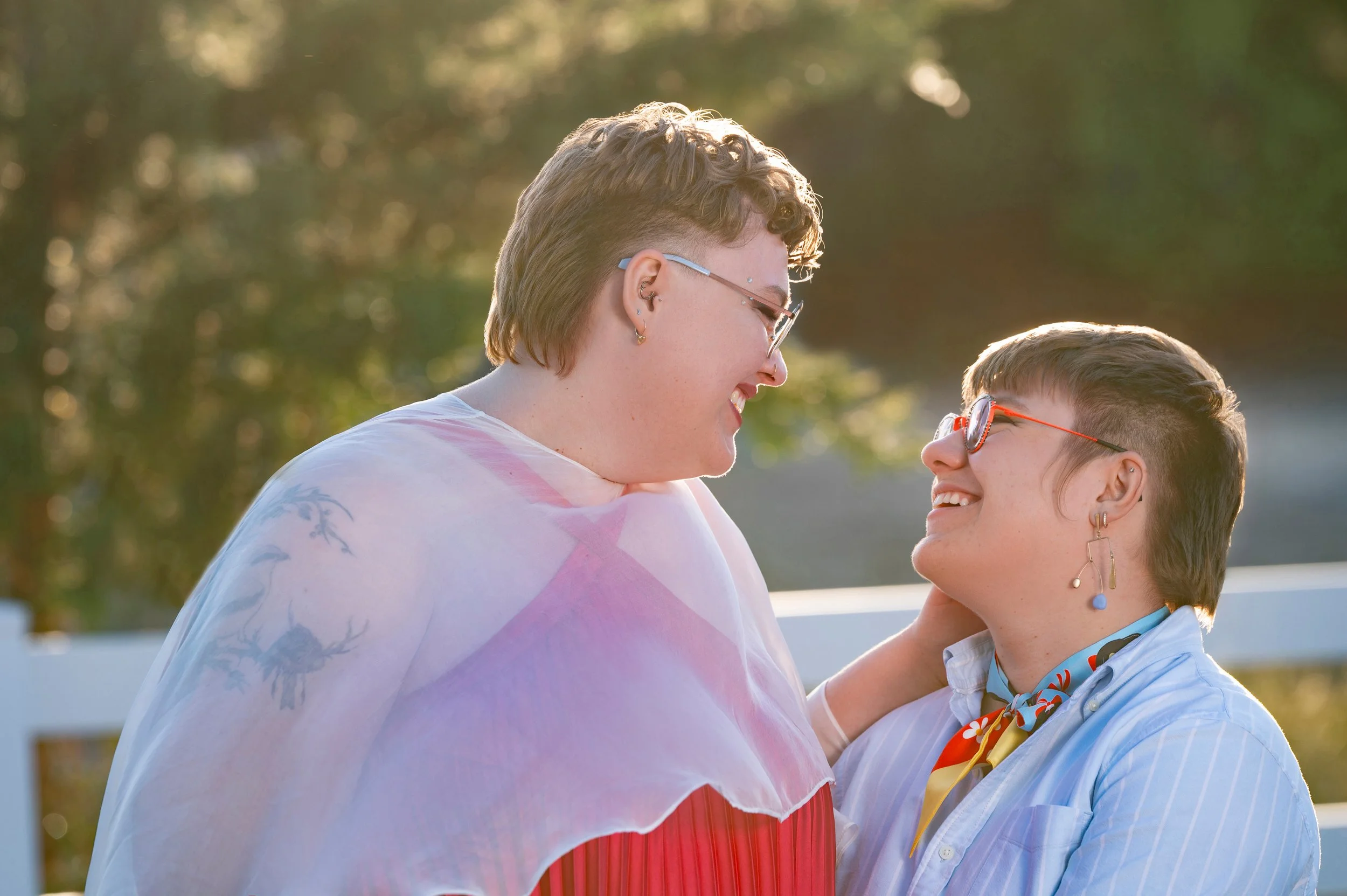 Two lesbian women smiling at each other on their wedding day outdoors in Reno