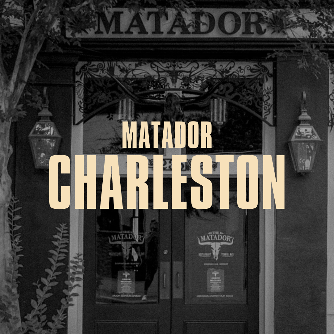 Black and white photo of the entrance to 'The Matador' restaurant with double glass doors, decorative lanterns, and a bull skull mounted above the door, with an overlay text reading 'Matador Charleston'.