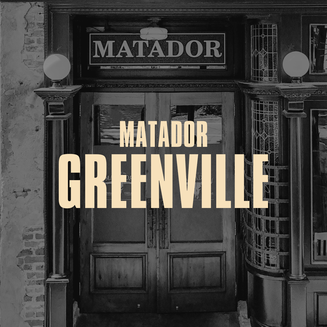 Black and white photo of entrance to Matador Greenville restaurant with large sign and decorative light fixtures