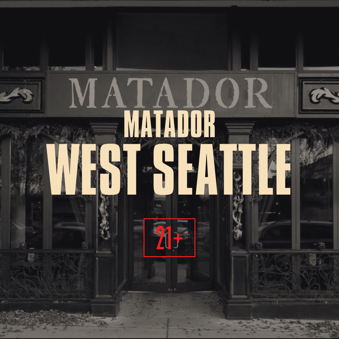 The entrance of a restaurant named Matador in West Seattle, with a sign above the door and floral decorations on the exterior, in black and white.
