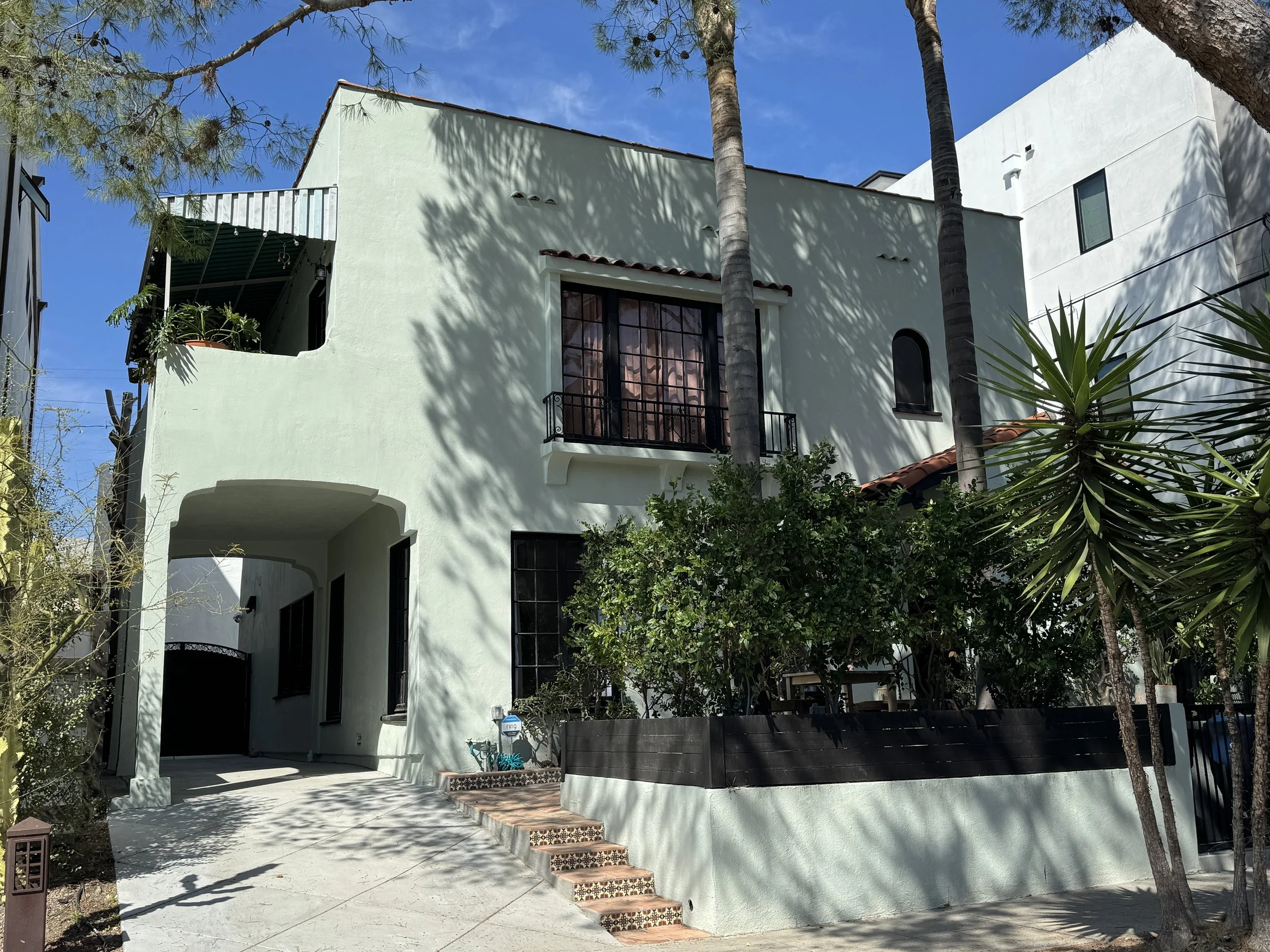 A light green Spanish Colonial Revival style duplex
