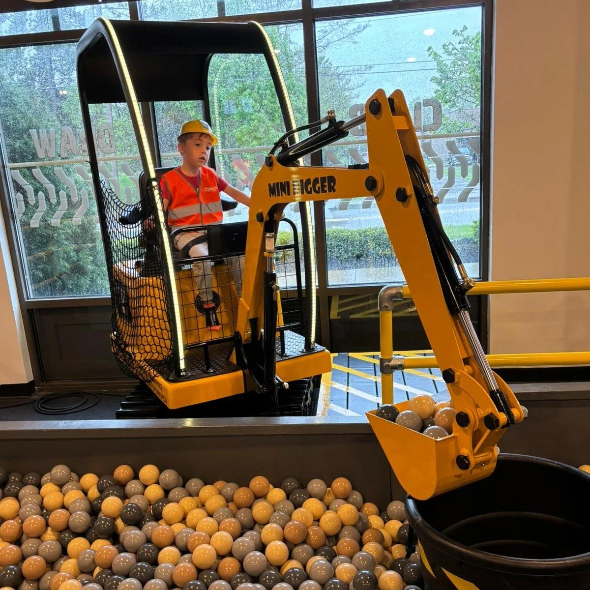child using kid-sized excavator at Construction Corner indoor play space Powell Ohio