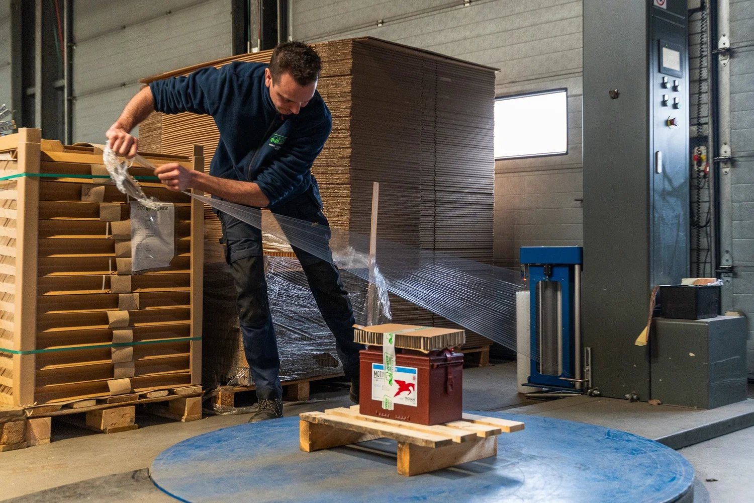 Medewerker verpakt een pallet in de productieomgeving