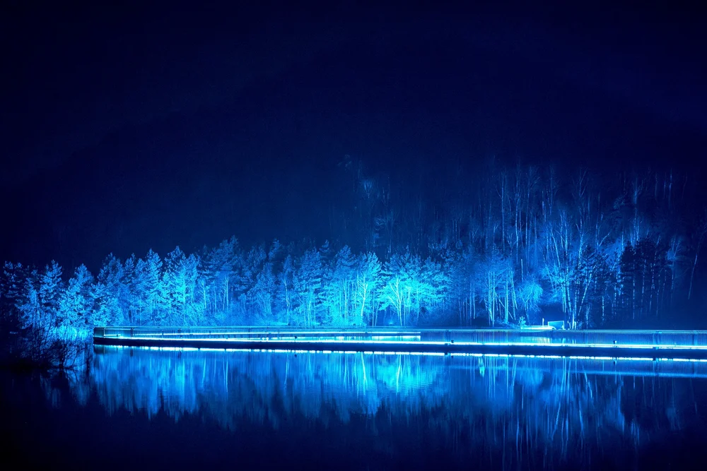 Foto 24: Watergedeelte van Luminoctis met blauwe lichtlijnen, reflecties, brugbeelden en installaties.