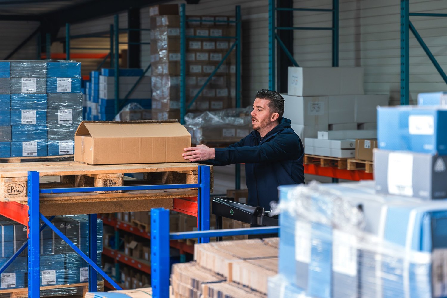 Magazijnmedewerker verplaatst een pakket op een rollenbaan