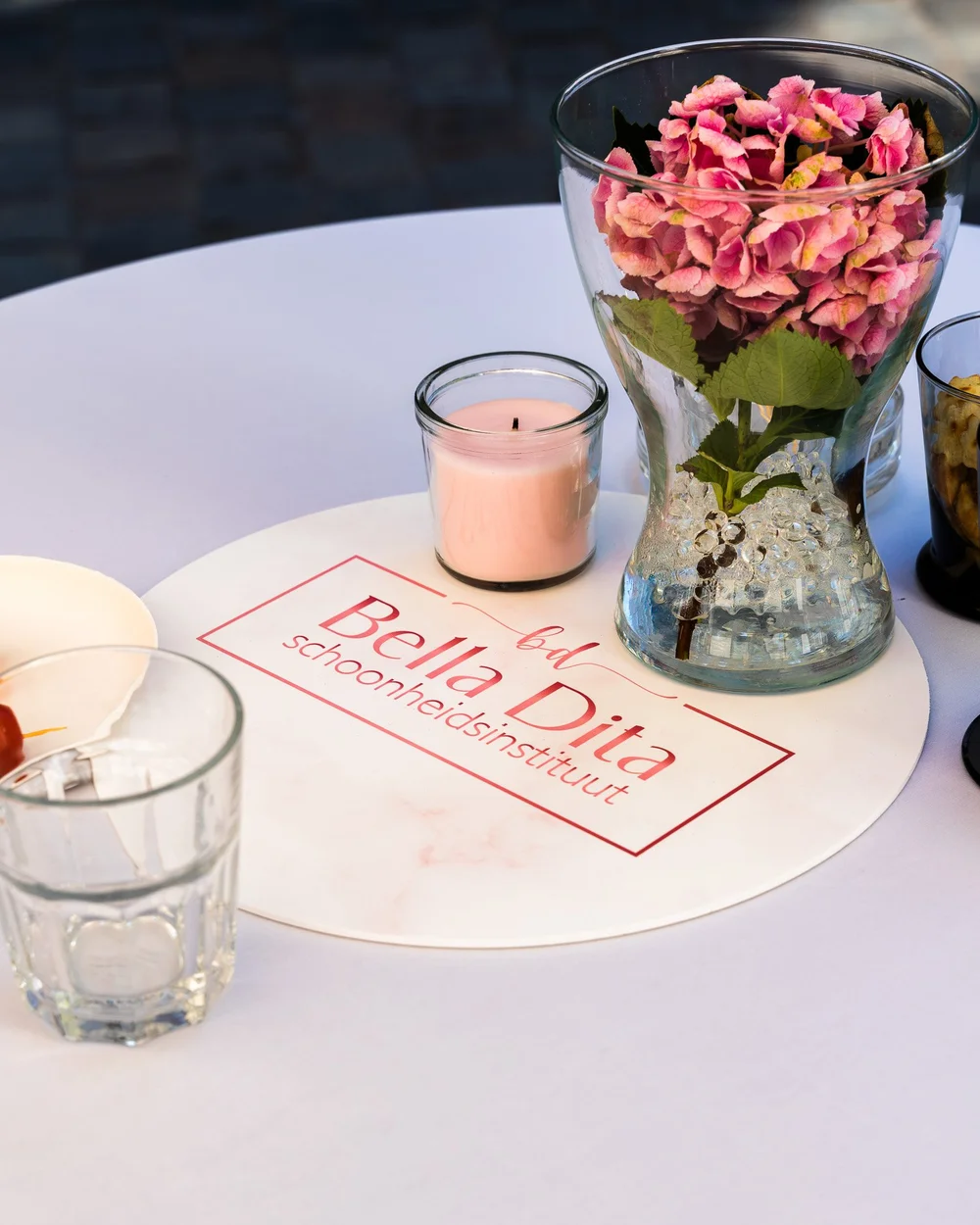 Detail van Bella Dita branding op tafel met bloemen en roze kaars