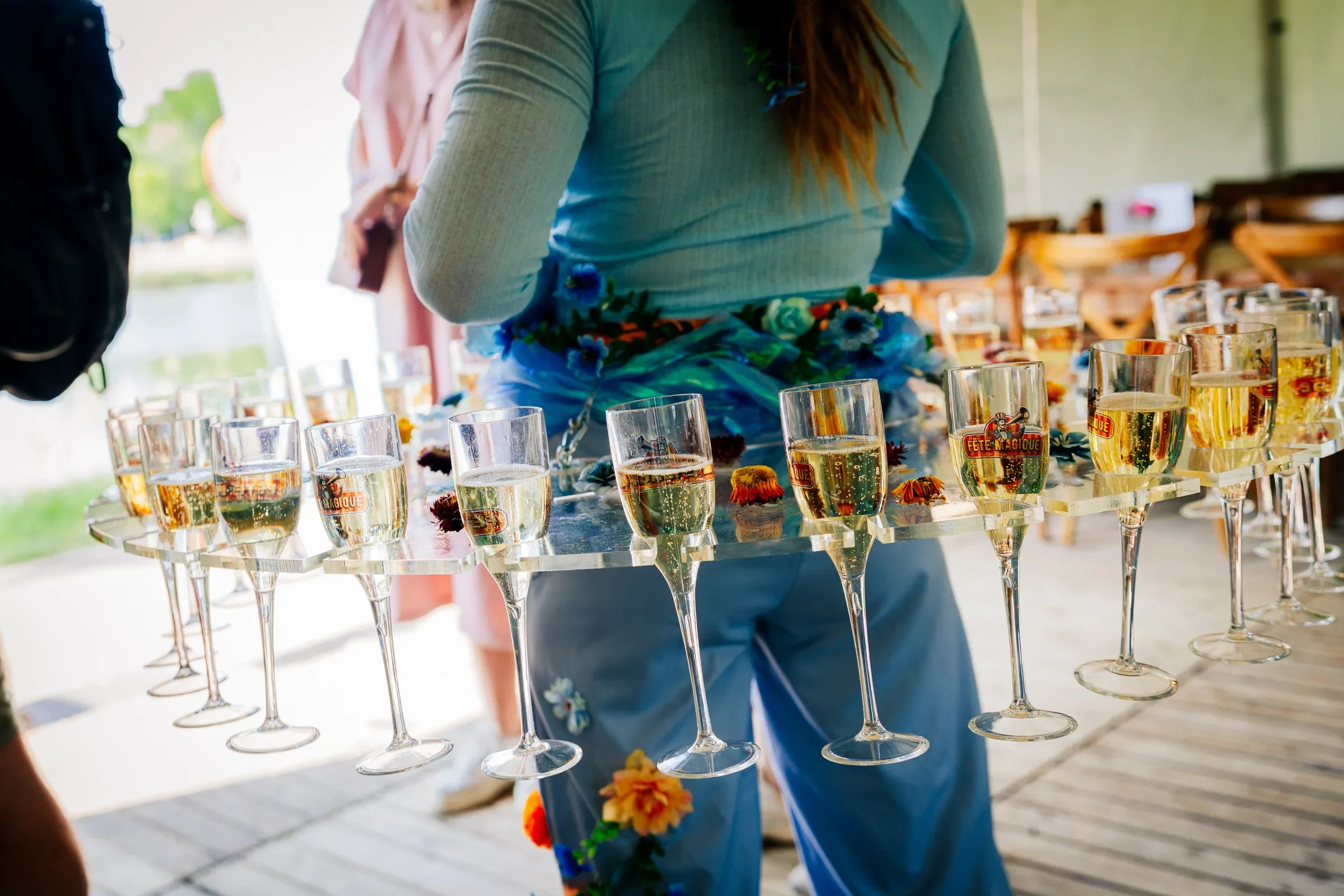 Man die glazen met champagne of prosecco serveert op een tafel, waarschijnlijk bij een feest of evenement.