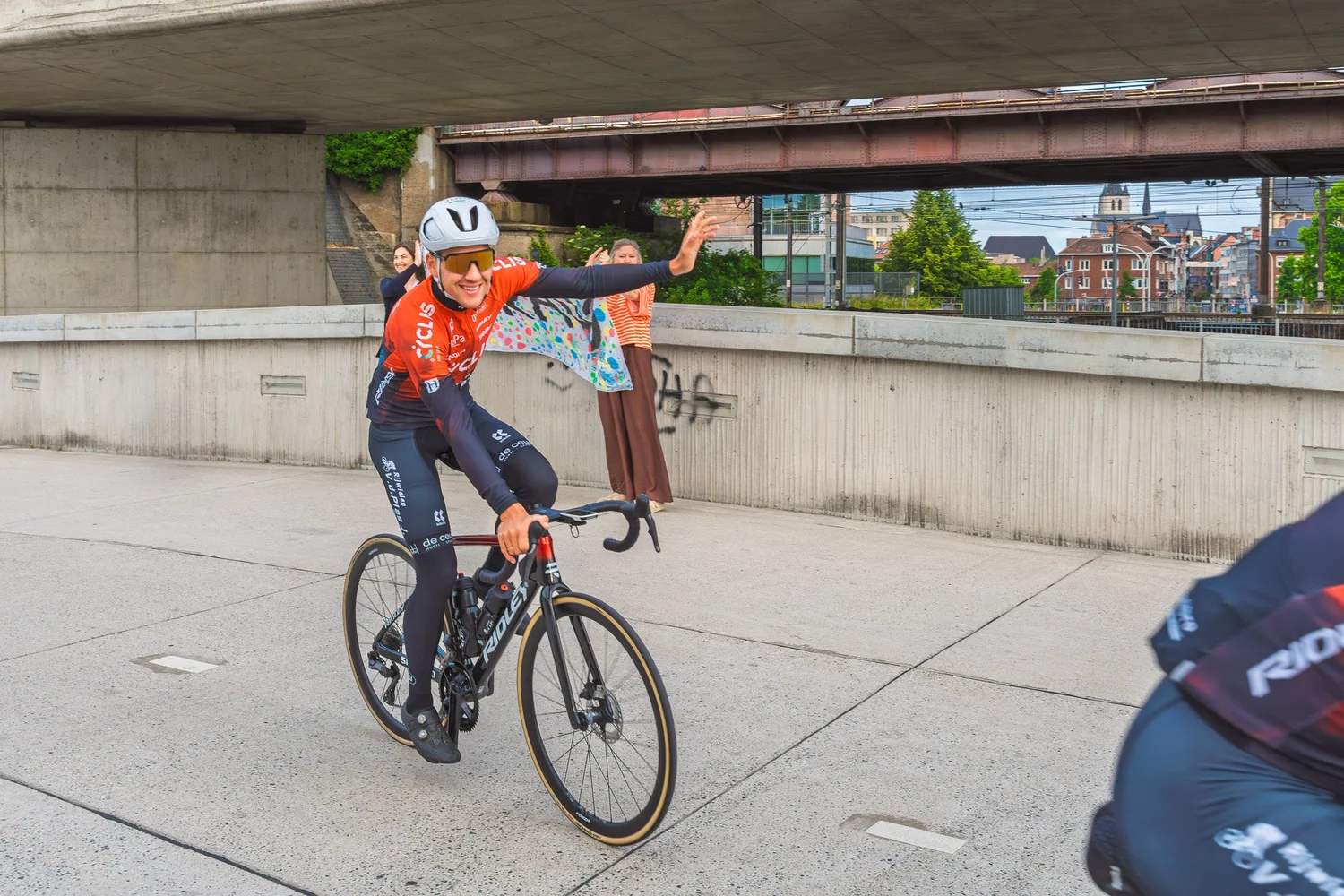 Cyclis renner zwaait terwijl hij voorbij rijdt