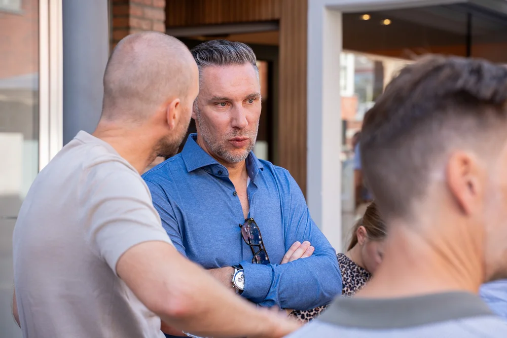 Twee gasten in gesprek buiten aan de inkom van Bella Dita