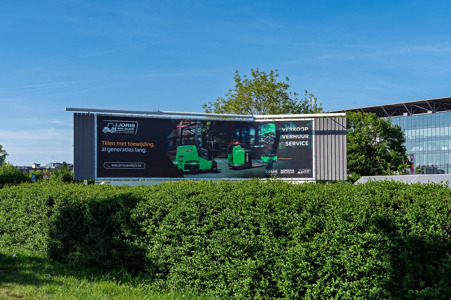 Brede locatiefoto van de Joris Van Dijck Heftrucks-banner bij het stadion van Antwerp FC