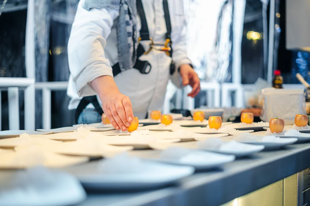 Chef die gerechten afwerkt tijdens Dinner in the Sky