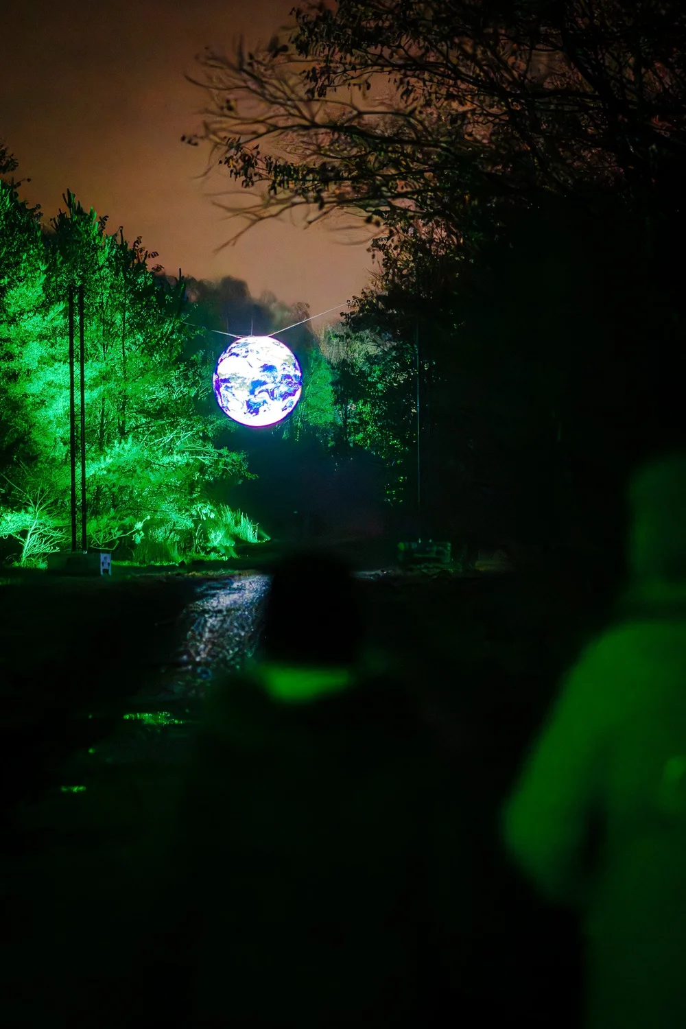 Foto 90: Aardegedeelte van Luminoctis met groen licht, organische vormen en natuurlijke installaties.