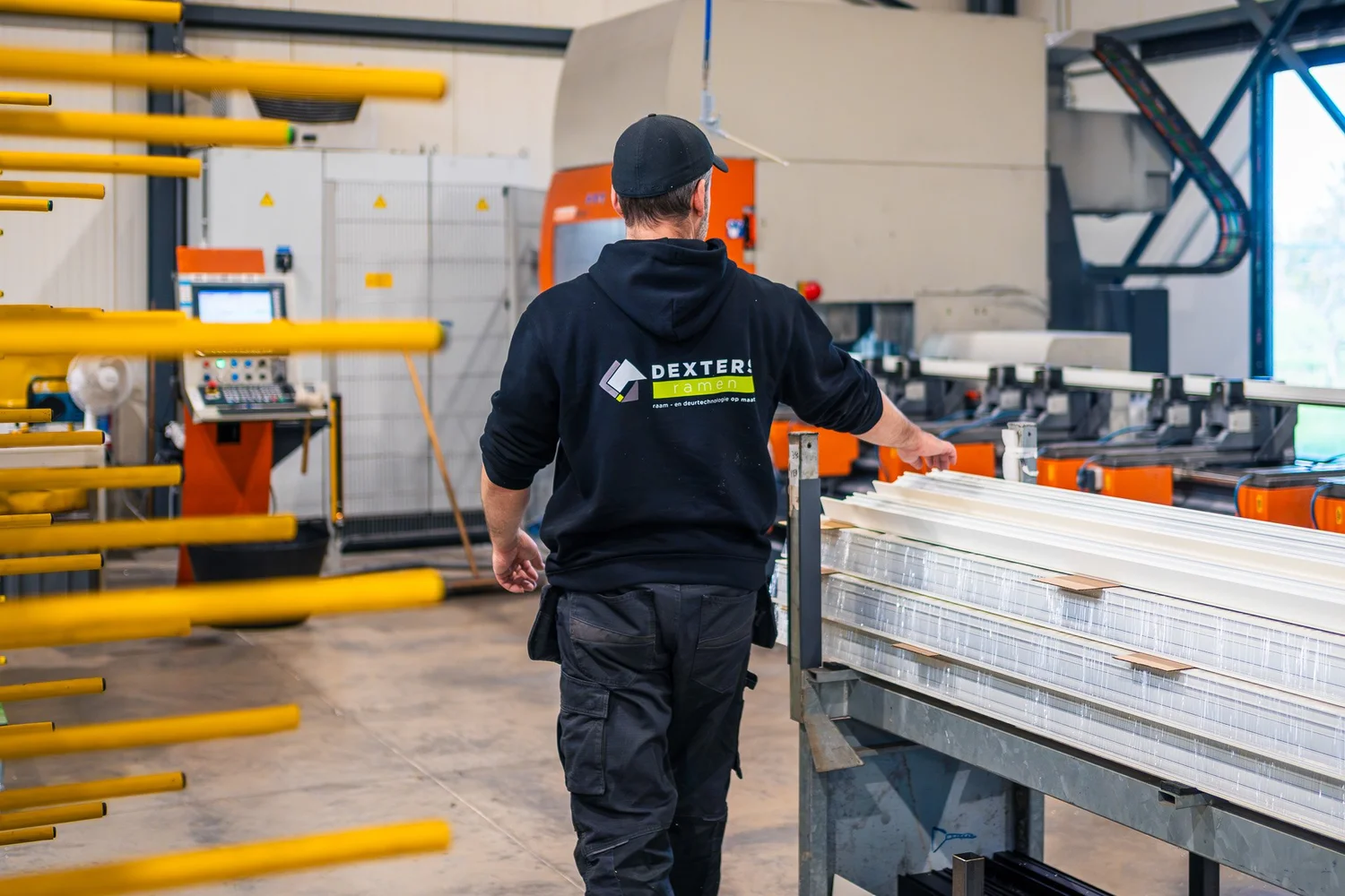 Medewerker bedient een machine in de productiehal van Dexters