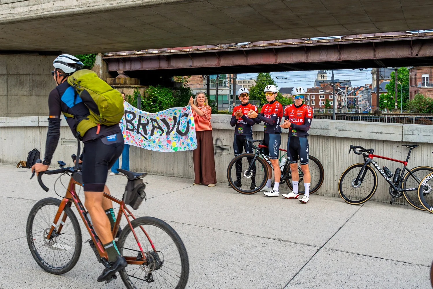 Fietser passeert Cyclis team en supporters