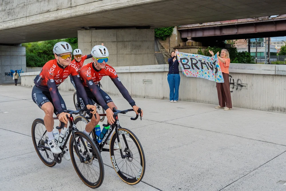 Cyclis fietsteam rijdt voorbij met Bravo spandoek