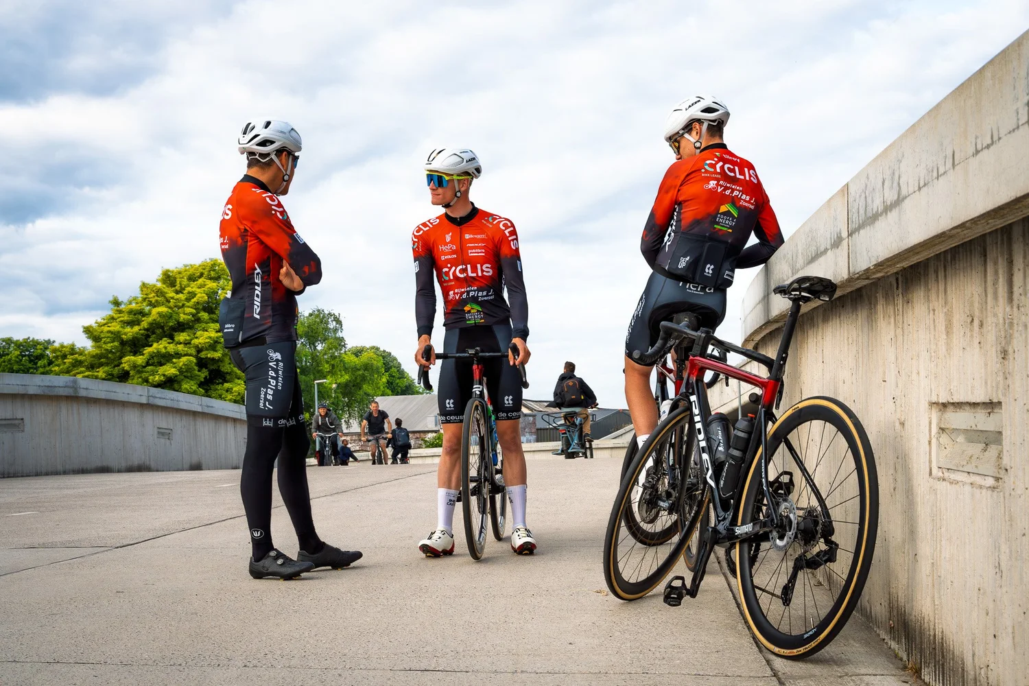 Cyclis team met fietsen aan betonnen muur
