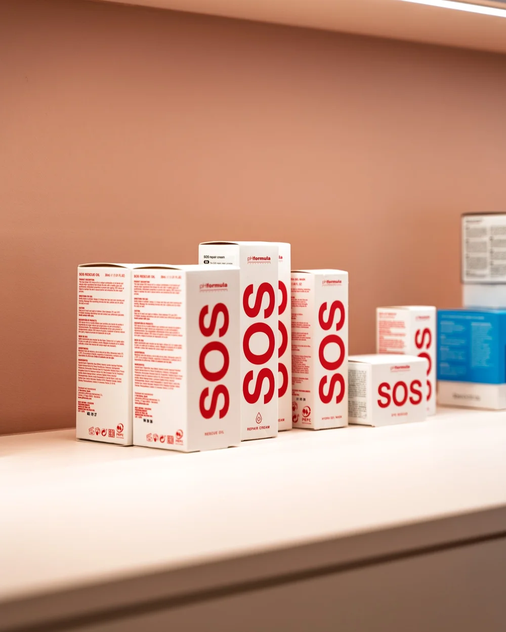 Producten van pHformula en SOS op een roze productschap bij Bella Dita