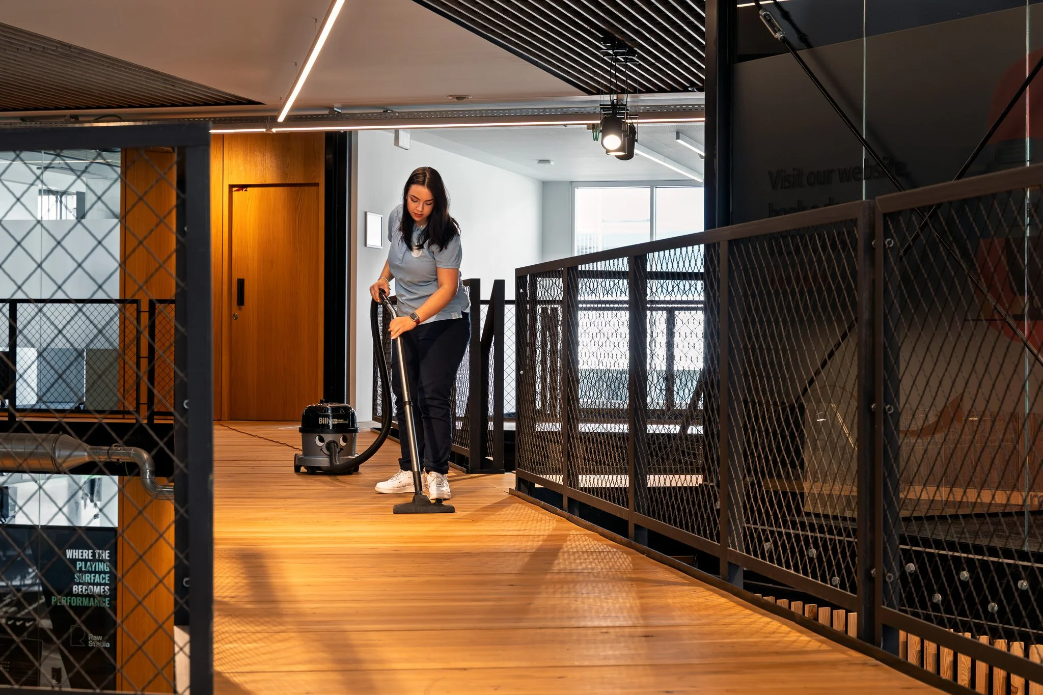 Medewerker van Libra Services stofzuigt een overdekte wandelgang