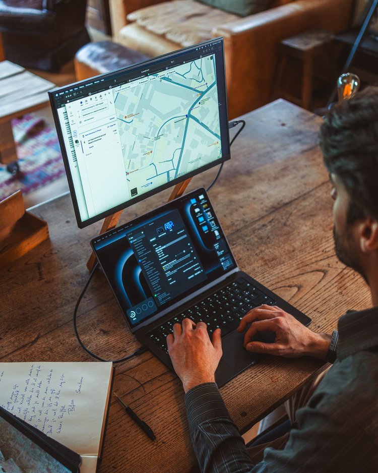 Lifestylefoto van een persoon die een laptop en Foote-monitor gebruikt