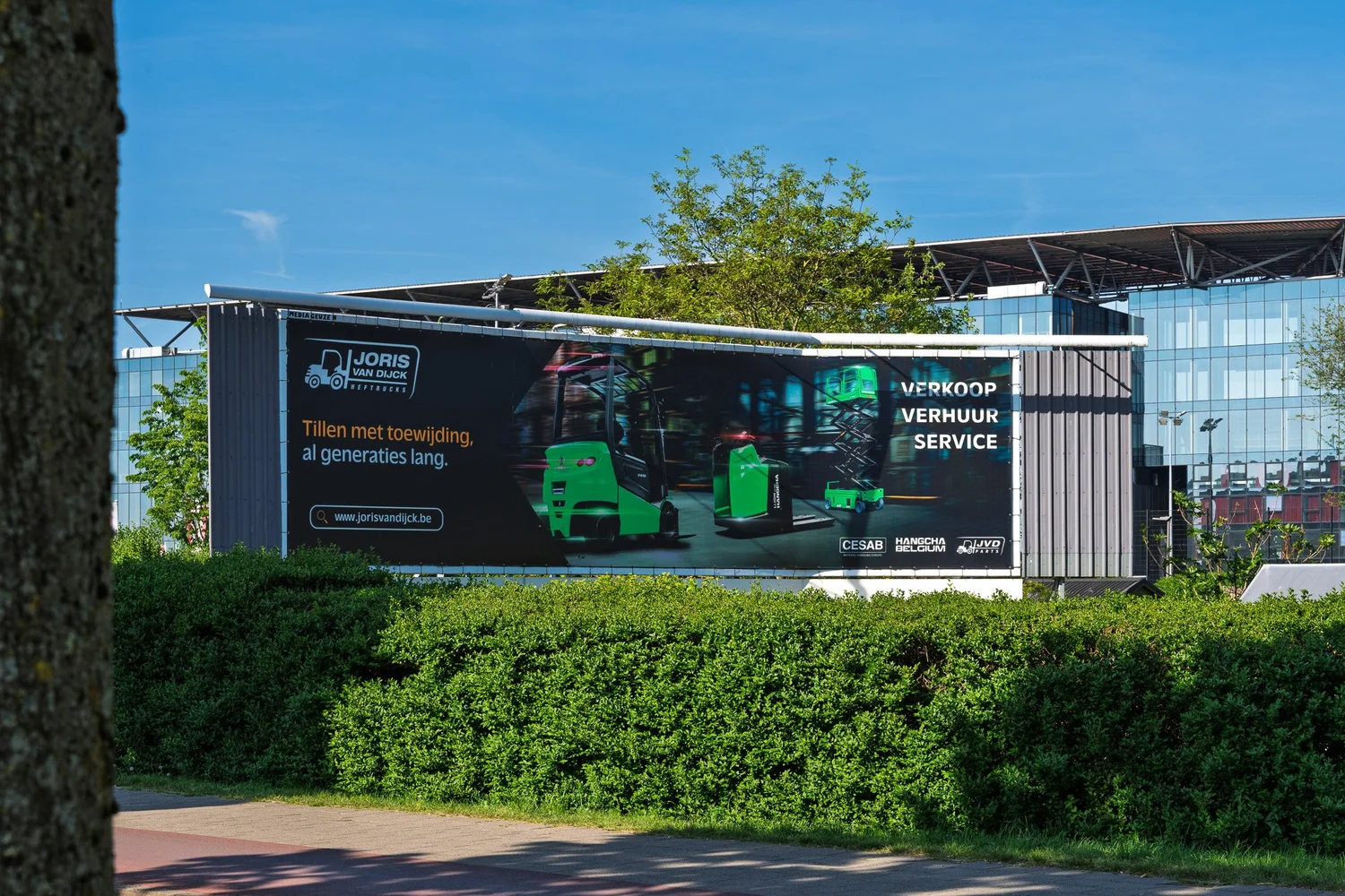 Offline campagnebanner voor Joris Van Dijck Heftrucks met het stadion van Antwerp FC op de achtergrond