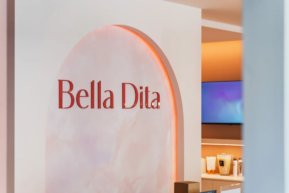 Bella Dita logo op roze boog gezien door het interieur