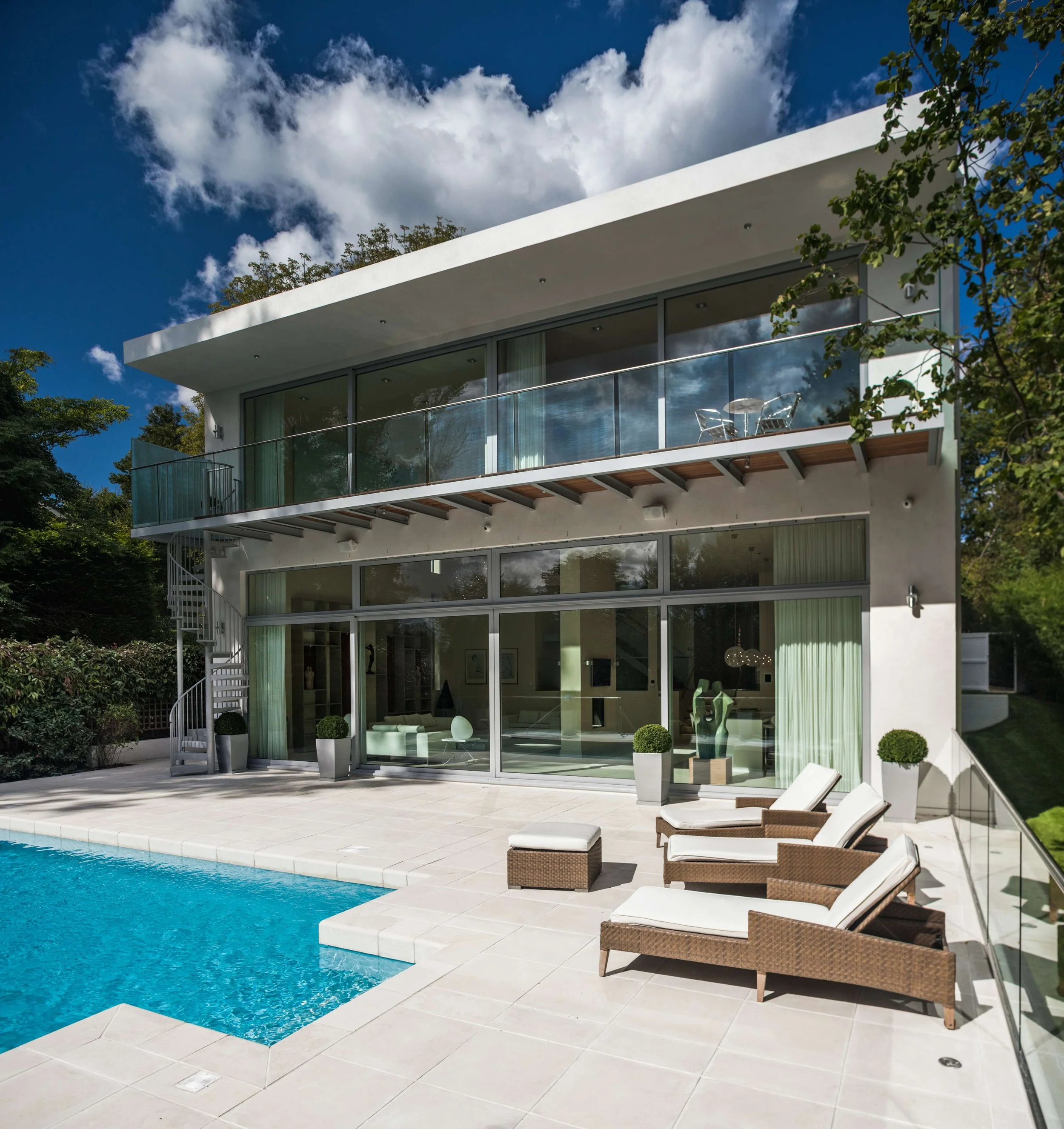 The exterior of Whitelights architecture project with a pool and loungers