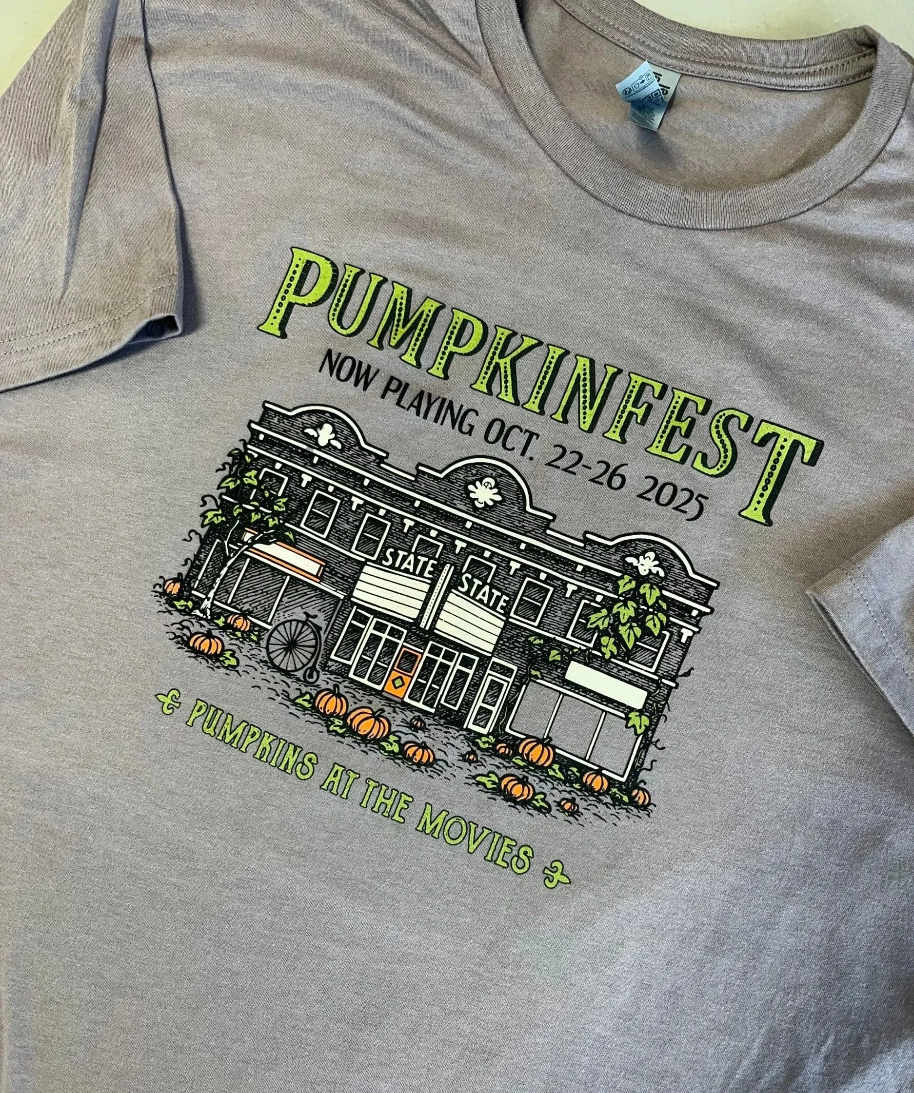 Close up image of screen printed tee, with the 2025 Pumpkinfest design. "Pumpkins at the movies"
