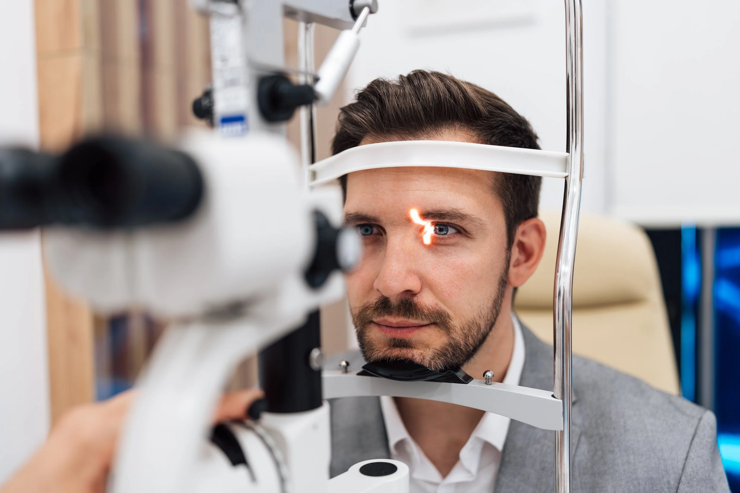 Man having an eye exam with an ophthalmoscope at Forever You & Eye Lasik Clinic.