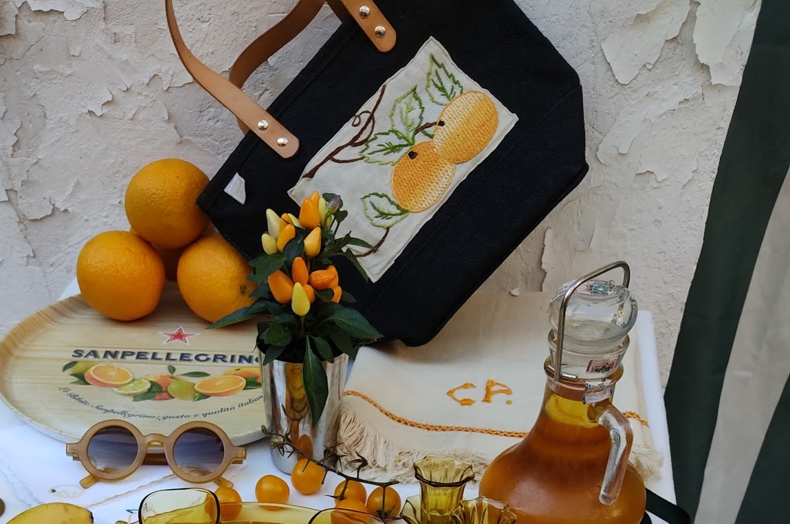 Black Jute Tote with Vintage Citrus Embroidery surrounded by a variety of vintage items in shades of yellow