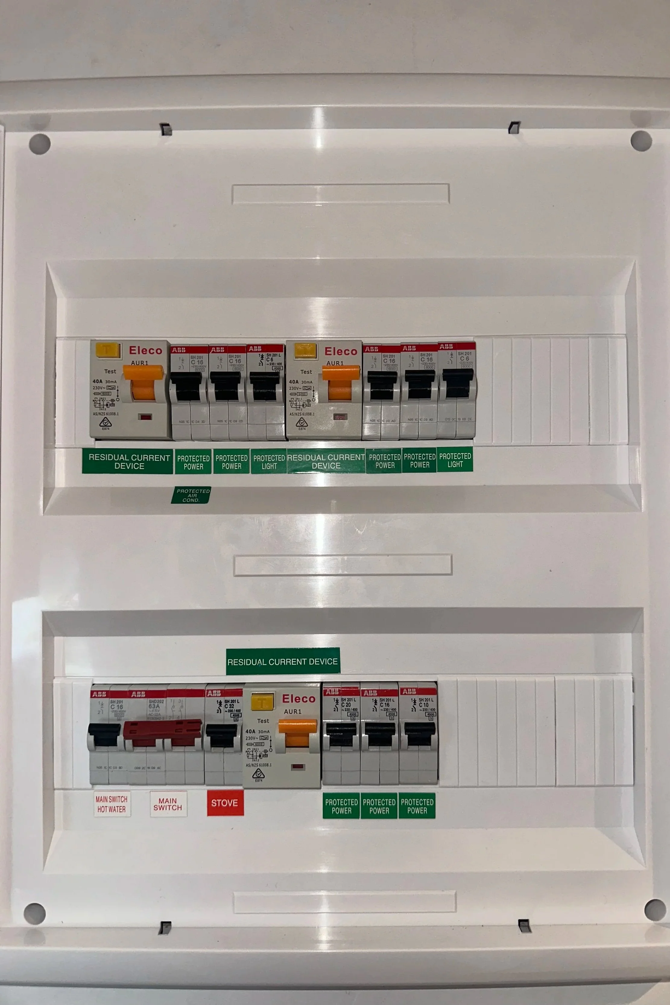 Electrical circuit breaker panel with multiple switches labeled with brand names and functions.