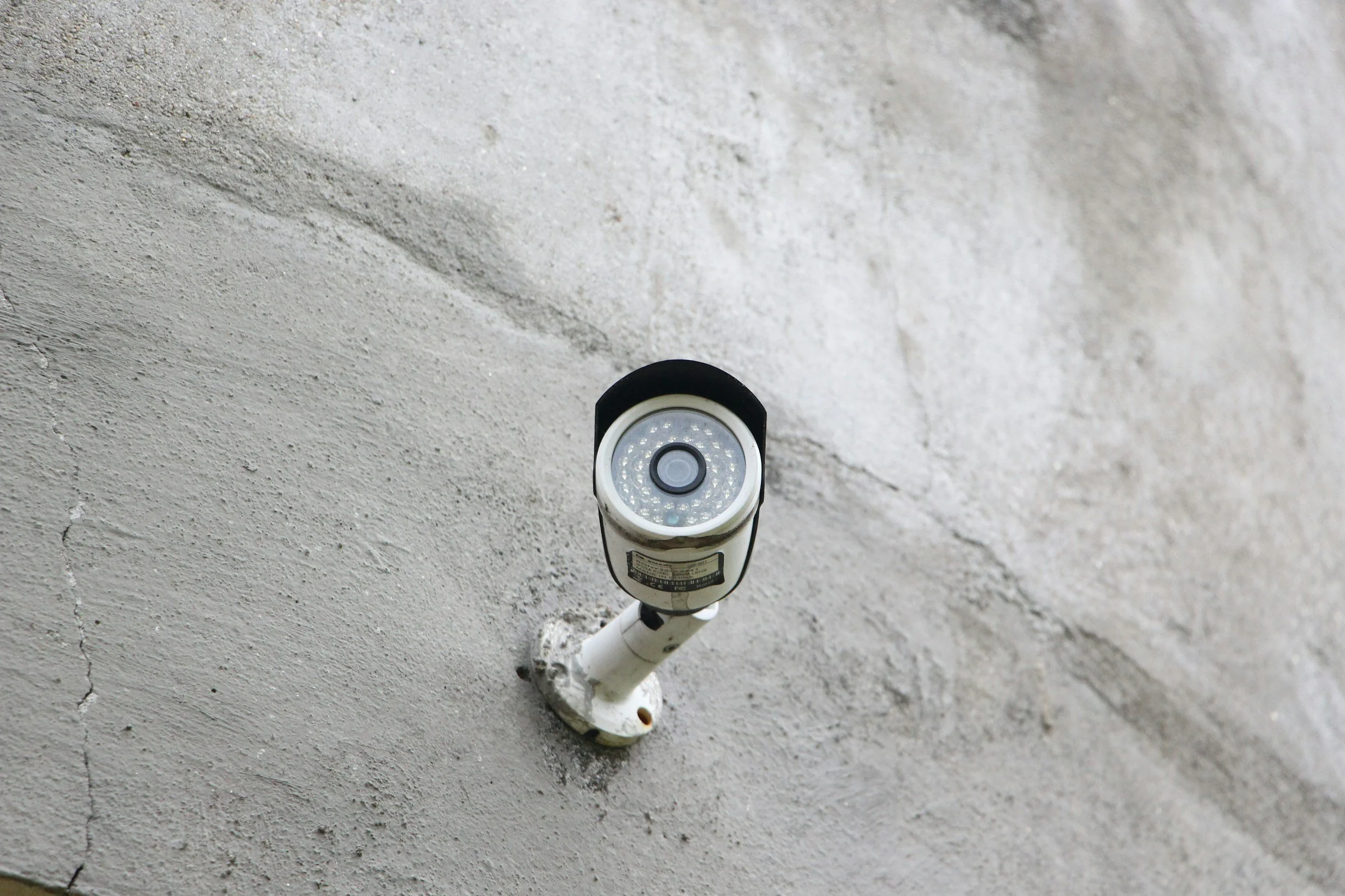 Security camera mounted on a concrete wall.