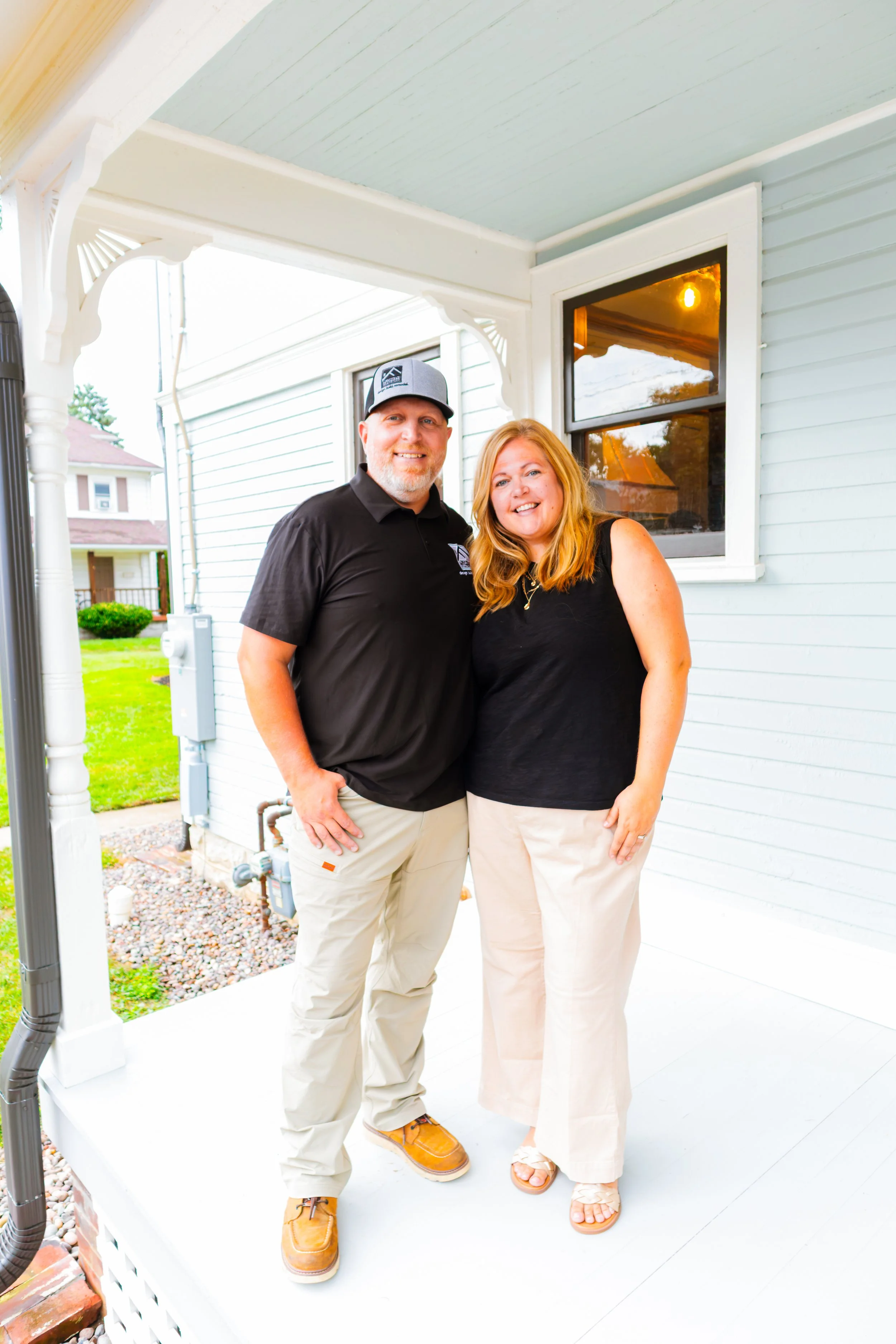 Joshua and Whitney Florkey standing together on the front porch of the Jefferson Street Historic Restoration in Brookville, Ohio.