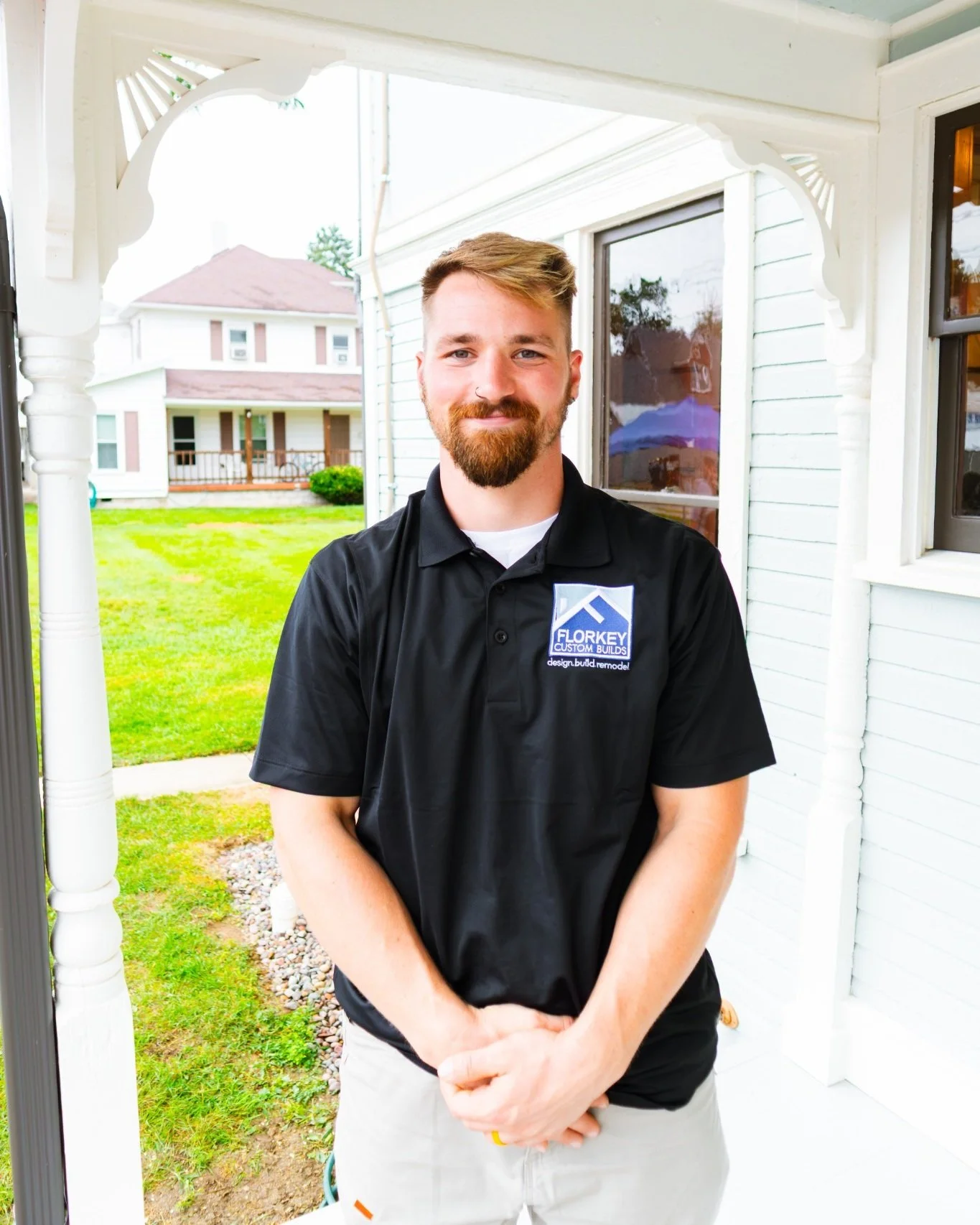 Corbin Hoblit of Florkey Custom Builds standing on the porch of a restored Victorian home in Brookville, Ohio.