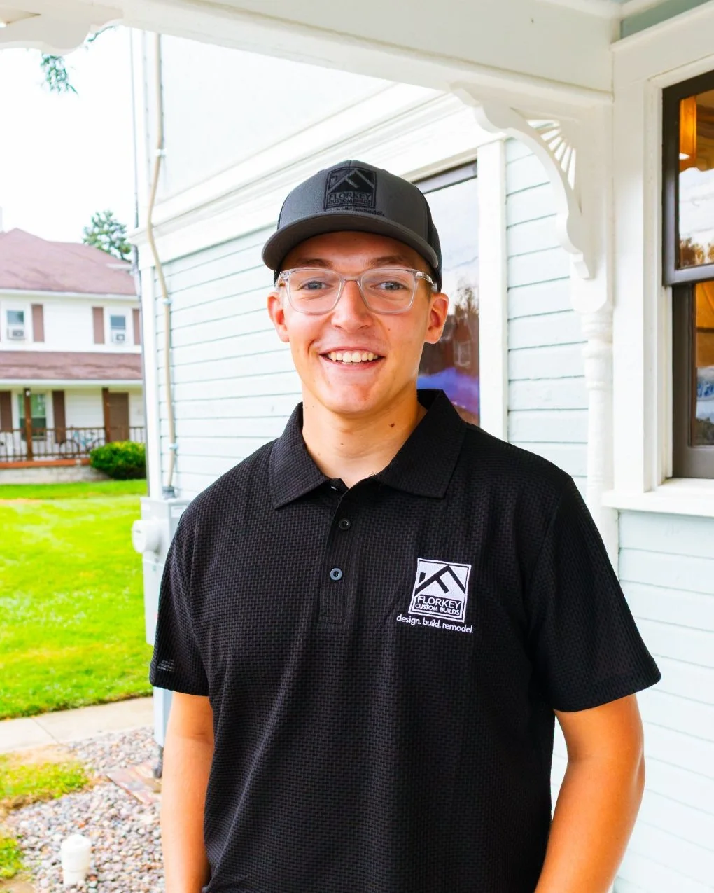 Greyson Florkey of Florkey Custom Builds standing on the porch of a restored Victorian home in Brookville, Ohio.
