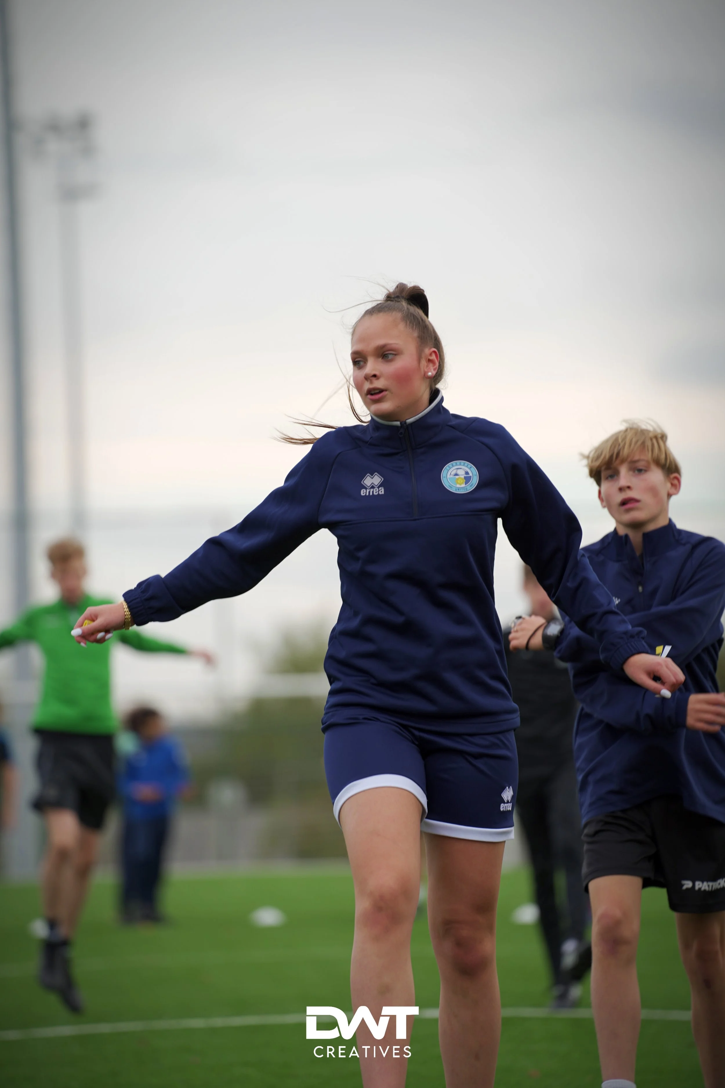 Voetballende jongeren tijdens een training op een grasveld.