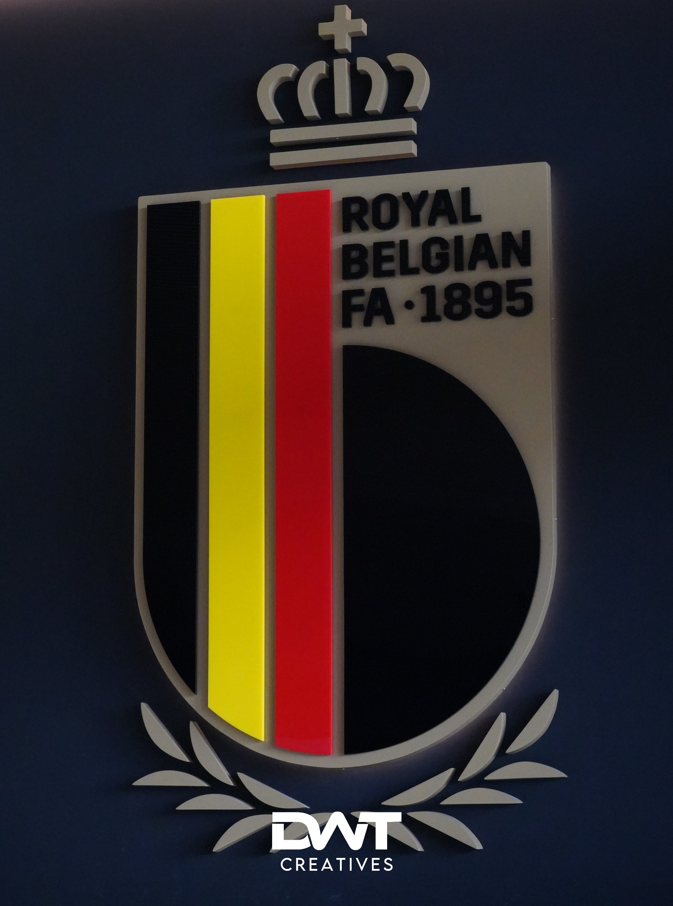 Embleem van de Koninklijke Belgische Voetbalbond met vlagkleuren en kroonsymbool.