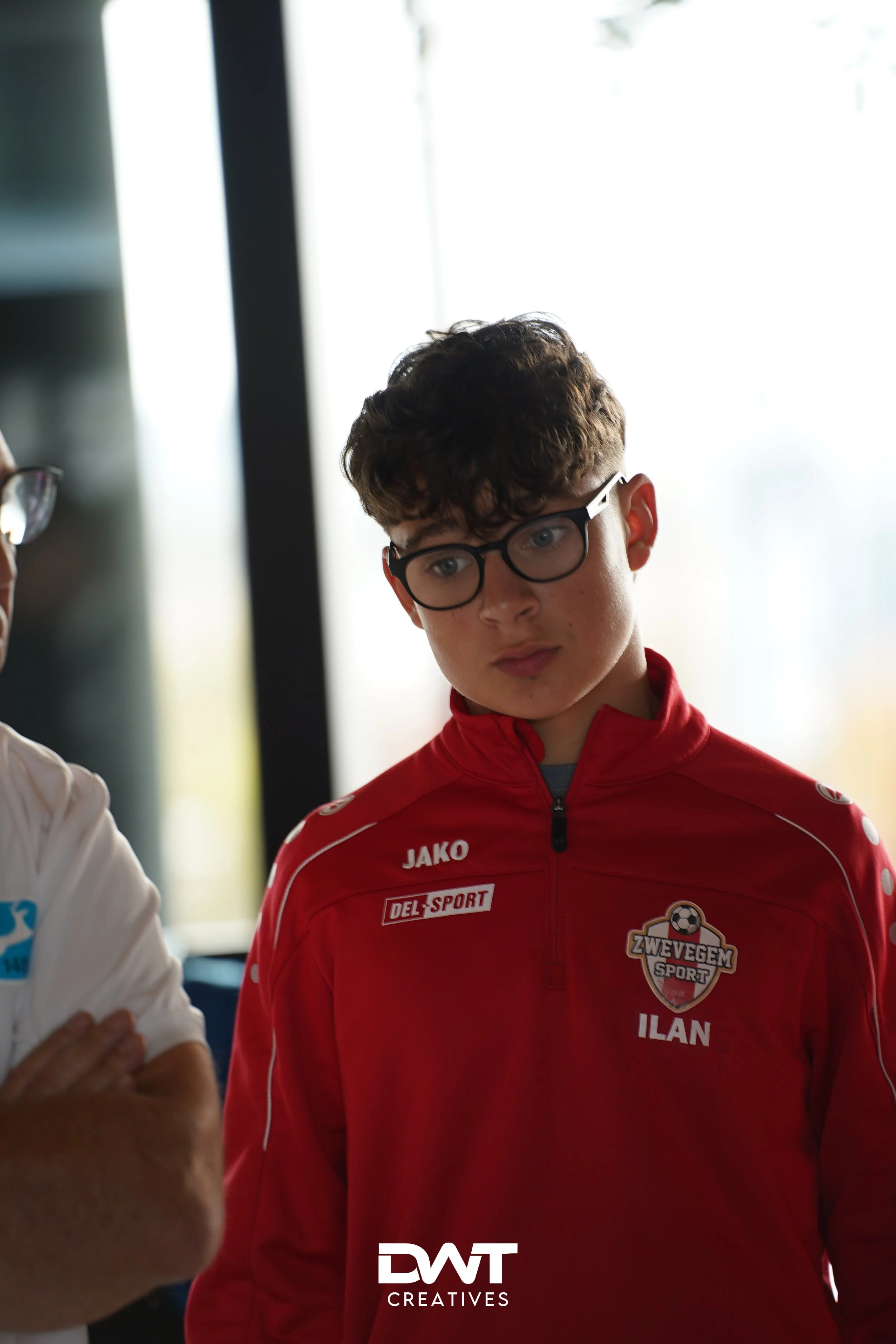 Jongen in sportkleding met bril.